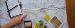 Carte, topoguide de la Véloscénie et smartphone posée sur une table