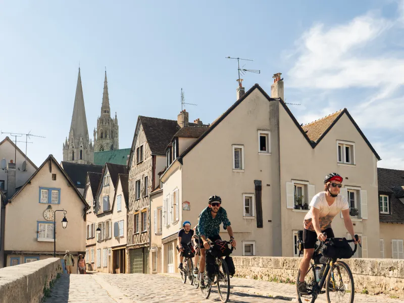 Cyclistes sur le point Bouju en basse-ville de Chartres avec la cathédrale apparaissant en arrière-plan.