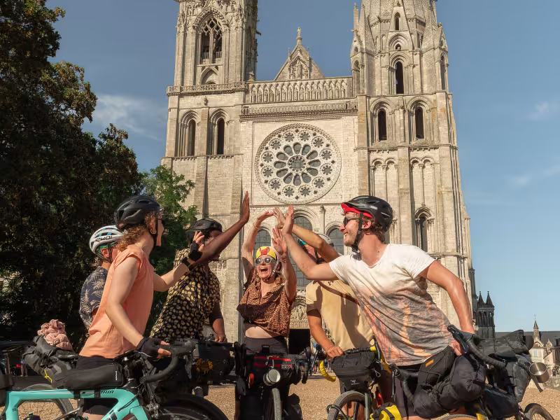 Cyclistes se félicitant à l'arrivée d'une étape devant la cathédrale de Chartres
