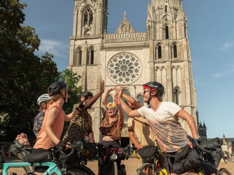 Cyclistes se félicitant à l'arrivée d'une étape devant la cathédrale de Chartres