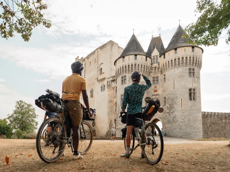 Deux cyclistes se tenant face au château des Comtes du Perche à Nogent-le-Rotrou