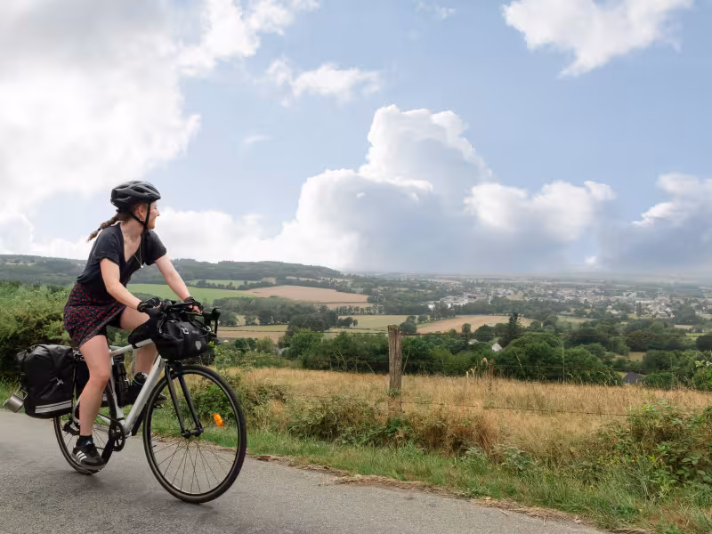 Cyclotouriste en plein ascension et regardant le paysage au loin.