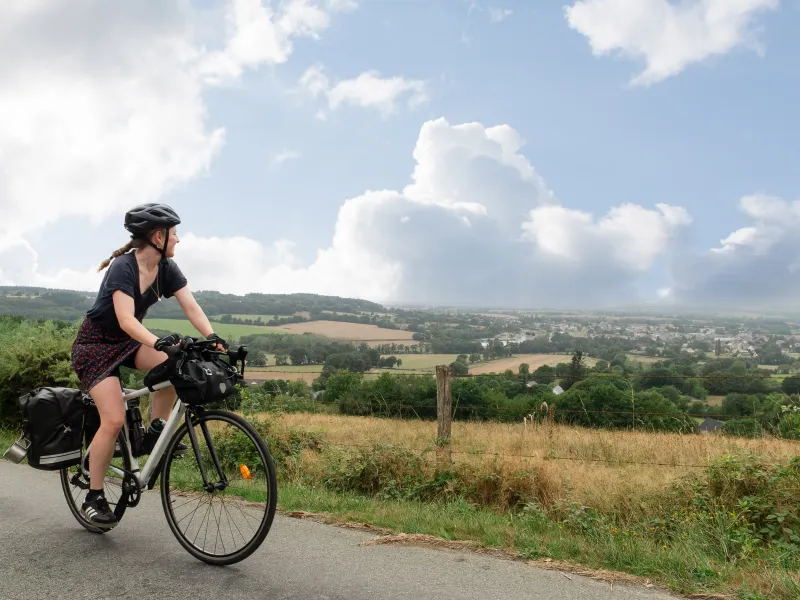 Cyclotouriste en plein ascension et regardant le paysage au loin.