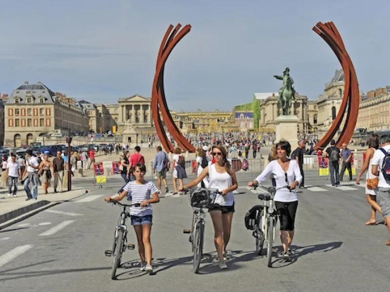 Cyclistes devant le château de Versailles