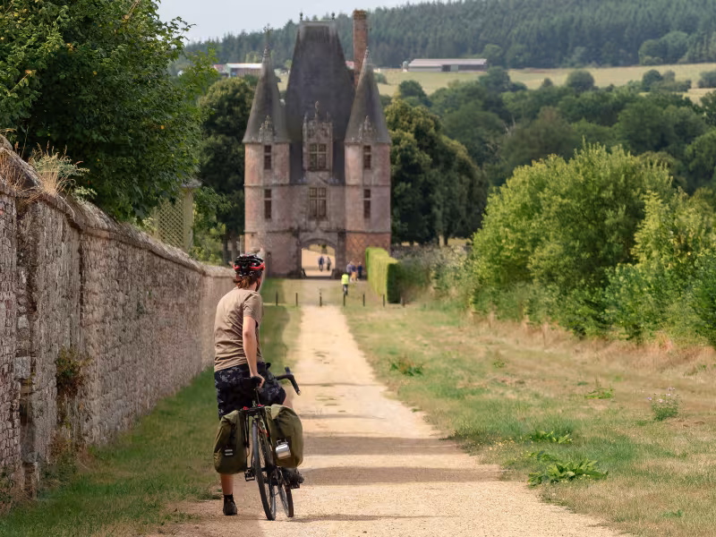 Cyclistes roulant en direction du château de Carrouges