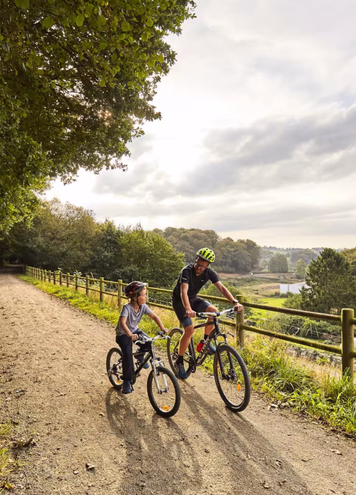Père et son fils roulant sur la voie verte près de Mortain sur la véloroute La Véloscénie 