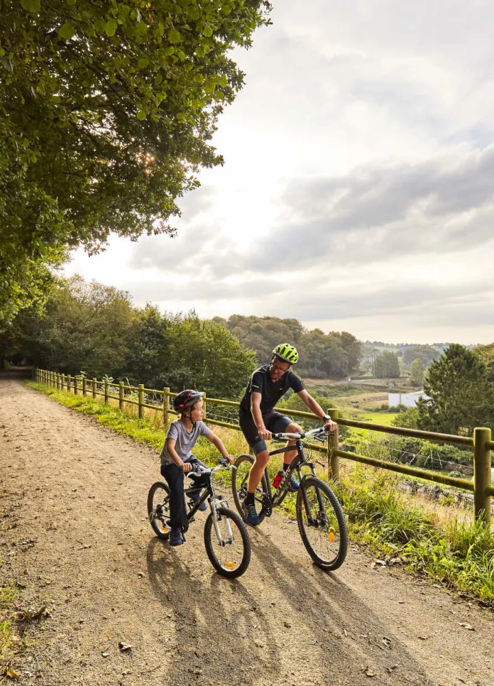 Père et son fils roulant sur la voie verte près de Mortain sur la véloroute La Véloscénie 