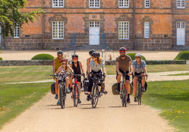 Groupes de voyageurs à vélo devant le château de Couternes dans l'Orne