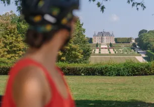 Cycliste regardant la perspective s'ouvrant sur le château de Sceaux depuis la Coulée Verte