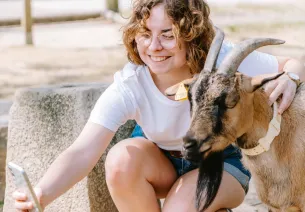 Une jeune femme se prend en photo avec une chèvre dans l'enclos de la Bergerie Nationale de Rambouillet