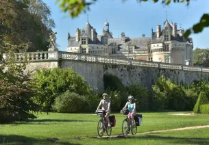2 voyageurs à vélo passent au pied du Château du Lude sur l'itinéraire de la Vallée de la Loir à Vélo