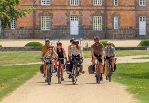 Groupes de voyageurs à vélo devant le château de Couternes dans l'Orne