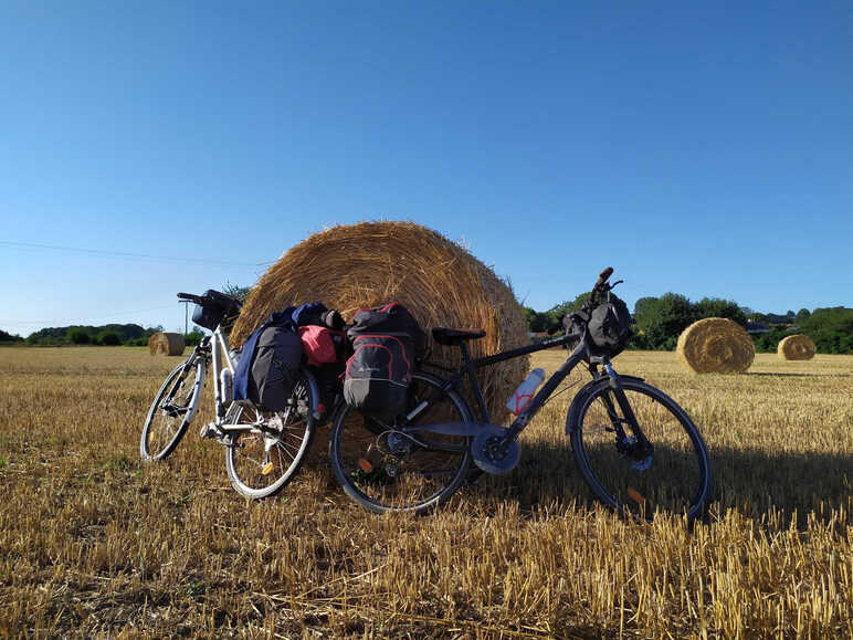 2 vélos devant une botte de paille dans un champs le long de La Véloscénie